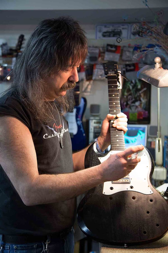 John Carlino repairing an electric guitar