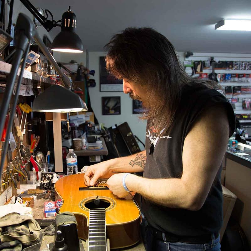 John Carlino repairing an acoustic guitar