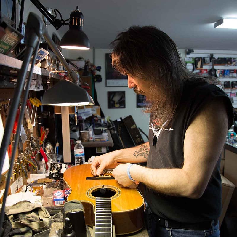 John Carlino stringing acoustic guitar